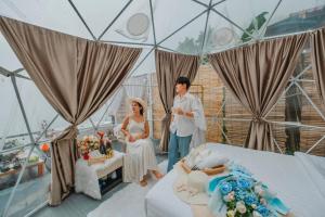 Un hombre y una mujer de pie en una habitación con un pastel. en ภูชี้ฟ้า นาราวิวล์แอดภูชี้ฟ้า Naraview at phuchifa, en Thoeng