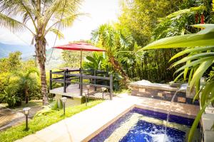 un patio con mesa y sombrilla junto a la piscina en Hermosa Casa y Cabañas en Barbosa, Antioquia, en Barbosa