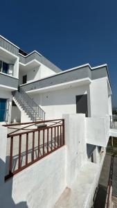 a white building with a staircase in front of it at Air Rooms in Lohārakot