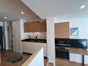 eine Küche mit weißen Schränken und schwarzen Arbeitsplatten in der Unterkunft Studio Front Neige - Parking inclus - Galerie marchande Isola 2000 in Isola 2000