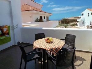 una mesa con sillas y un bol de fruta en el balcón en Parque Royal 1 Apartamento Costa Adeje, en Adeje