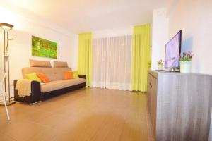 Una sala de estar con un sofá y un televisor. en Parque Royal 1 Apartamento Costa Adeje, en Adeje