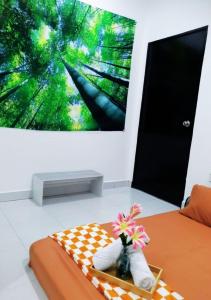 a room with a bed with a vase with flowers in it at 12pax Senai RestHome near Senai Airport in Kampung Seelung