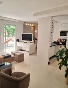 Μια τηλεόραση ή/και κέντρο ψυχαγωγίας στο Quarto e Banheiro privativo Praia da Costa Pé Na Areia