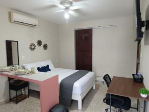 a bedroom with a bed and a desk and a table at Suite 105 Cordoba centro y estacionamiento in Córdoba