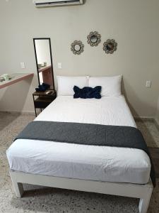 a bedroom with a bed with a black bow tie on it at Suite 105 Cordoba centro y estacionamiento in Córdoba