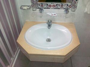 a white sink in a bathroom with a counter at Real Caparica Hotel in Costa da Caparica