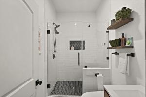 un bagno bianco con doccia e WC di Hardy House Vintage Bungalow, Huge Yard! a Houston Altre 40 foto