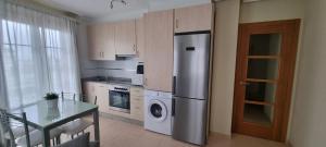 a kitchen with a stainless steel refrigerator and a glass table at Piso con piscina entre 2 playas - Floor with pool between 2 beaches in O Porto de Espasante +36 photos