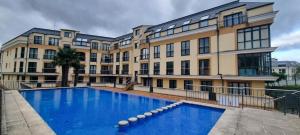 a building with a swimming pool in front of a building at Piso con piscina entre 2 playas - Floor with pool between 2 beaches in O Porto de Espasante