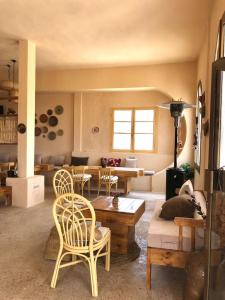 a living room with a couch and a table and chairs at échappée troglodyte unique in Tūjān +28 photos