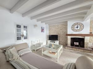 Una sala de estar con un sofá y una chimenea. en Maison Magnolia proche de la plage à Sainte Marie de Ré, en Sainte-Marie-de-Ré