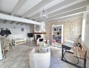 sala de estar con muebles blancos y pared de ladrillo en Maison Magnolia proche de la plage à Sainte Marie de Ré, en Sainte-Marie-de-Ré 16 fotos más