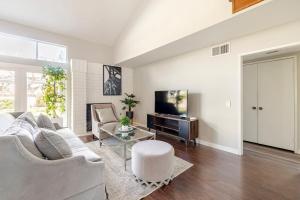 Una sala de estar con un sofá blanco y un televisor. en Spacious 4-bedroom house in tranquil Rowland Heights with City View, en Rowland Heights