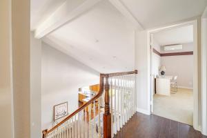 una escalera en una casa con paredes blancas y suelo de madera en Spacious 4-bedroom house in tranquil Rowland Heights with City View, en Rowland Heights