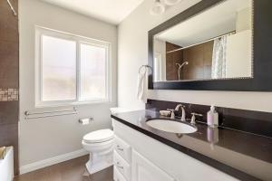 Un baño con lavabo, inodoro y espejo. en Spacious 4-bedroom house in tranquil Rowland Heights with City View, en Rowland Heights 67 fotos más