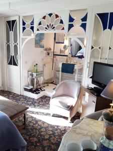 a living room with blue and white walls and a tv at " Chimay B & B " - ptits déj gourmands proposés in Chimay