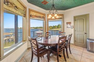 a dining room with a table and chairs and windows at Lake Escape Paradise Premier fishing getaway in Zwolle