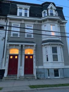 a large house with red doors on a street at Castle on Coburg in Rothesay