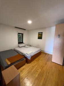 Un dormitorio con dos camas y suelo de madera. en Vacation spot in Sarajevo in a calmest spacious area, en Sarajevo