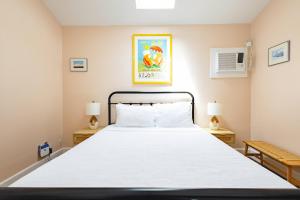 Un dormitorio con una gran cama blanca con dos lámparas. en Sugar Pie Suite, en Key West