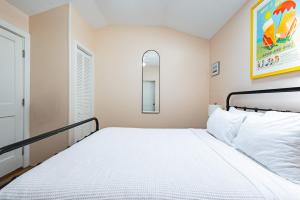 Un dormitorio pequeño con una cama y un espejo. en Sugar Pie Suite, en Key West 3 fotos más