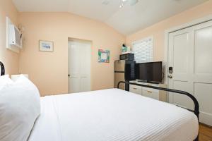 Un dormitorio con una cama y un televisor de pantalla plana. en Sugar Pie Suite, en Key West