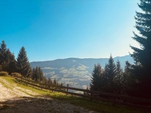 a fence on a dirt road with mountains in the background at Naturblick in Donnersbach