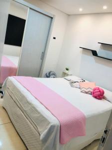 a bedroom with a bed with a pink blanket and a mirror at Quartos Privados em casa Mobiliada in Londrina
