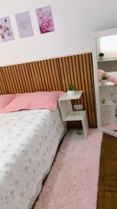 a bedroom with a bed with a wooden headboard at Quartos Privados em casa Mobiliada in Londrina