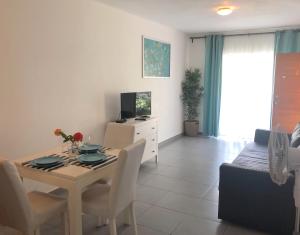 comedor y sala de estar con mesa y TV en Condo E2 1bdr 1bth, en Punta Cana