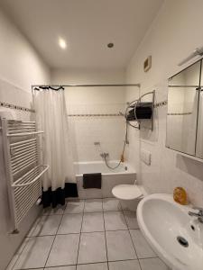 a white bathroom with a sink and a toilet at Deutscher Hof in Plauen +106 photos
