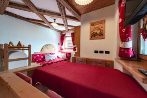 a dining room with a red table and chairs at Chalet Pian in Campitello di Fassa