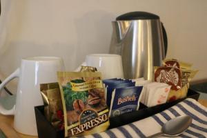 a table topped with a box of snacks and a pitcher at Hermitage Motel in Muswellbrook