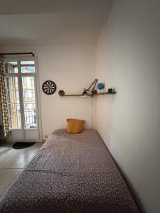 a bedroom with a bed with a yellow pillow on it at Appartement Cozy in Céret +31 photos