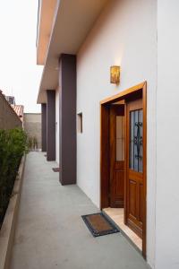 ペルイベにあるMundi Studios Peruíbe ( 60 metros do mar)の木の扉と歩道のある建物