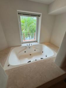a large white bath tub in a room with a window at Exclusive Luxury Waterfront Villa in Marina Real in Zihuatanejo