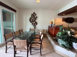 a dining room with a glass table and chairs at Exclusive Luxury Waterfront Villa in Marina Real in Zihuatanejo