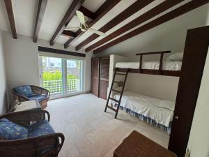 a room with two bunk beds and a ceiling fan at Exclusive Luxury Waterfront Villa in Marina Real in Zihuatanejo