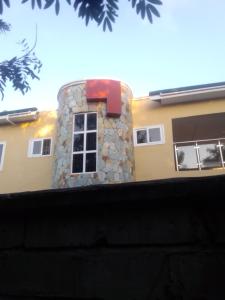 un edificio con una chimenea de piedra con una ventana en Glitz City hotel, en Cape Coast