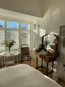 ein Schlafzimmer mit einem Bett, einem Tisch und einem Spiegel in der Unterkunft 7 Goathill Crescent in Stornoway