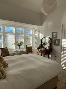 a large white bedroom with a large bed and windows at 7 Goathill Crescent in Stornoway