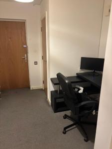 una oficina con un escritorio y una silla y una computadora en One Bedroom Apartment in Greenwich Peninsula, en Moffat