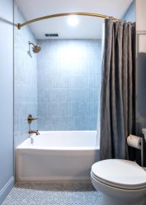 a bathroom with a tub and a toilet and a sink at Hollyhock Suite 506 in Louisville +1 photo