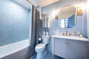 a bathroom with a toilet and a sink and a mirror at Hollyhock Suite 506 in Louisville