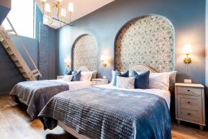 two beds in a room with blue walls at Hollyhock Suite 506 in Louisville