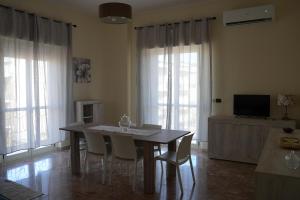 une salle à manger avec une table, des chaises et une télévision dans l'établissement La Regina del Sole, à Reggio de Calabre