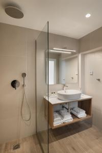 a bathroom with a sink and a mirror and a shower at ASTIKON Xenofontos Suites in Athens +35 photos