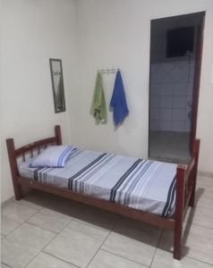 Una cama en una habitación con toallas colgadas en la pared. en Pousada Central, en Guaratinguetá