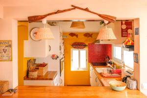 a kitchen with yellow walls and white cabinets at Casa do Mar - Familiar T3 Duplex - Terraço - Central in Nazaré